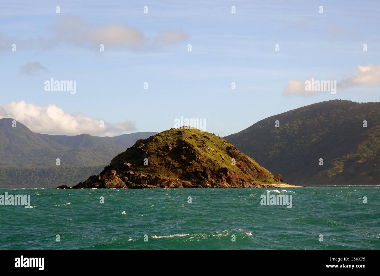 Isolotto roccioso off Archer punto, con Mt Amos in background, a sud di Cooktown, Queensland, Australia Foto Stock