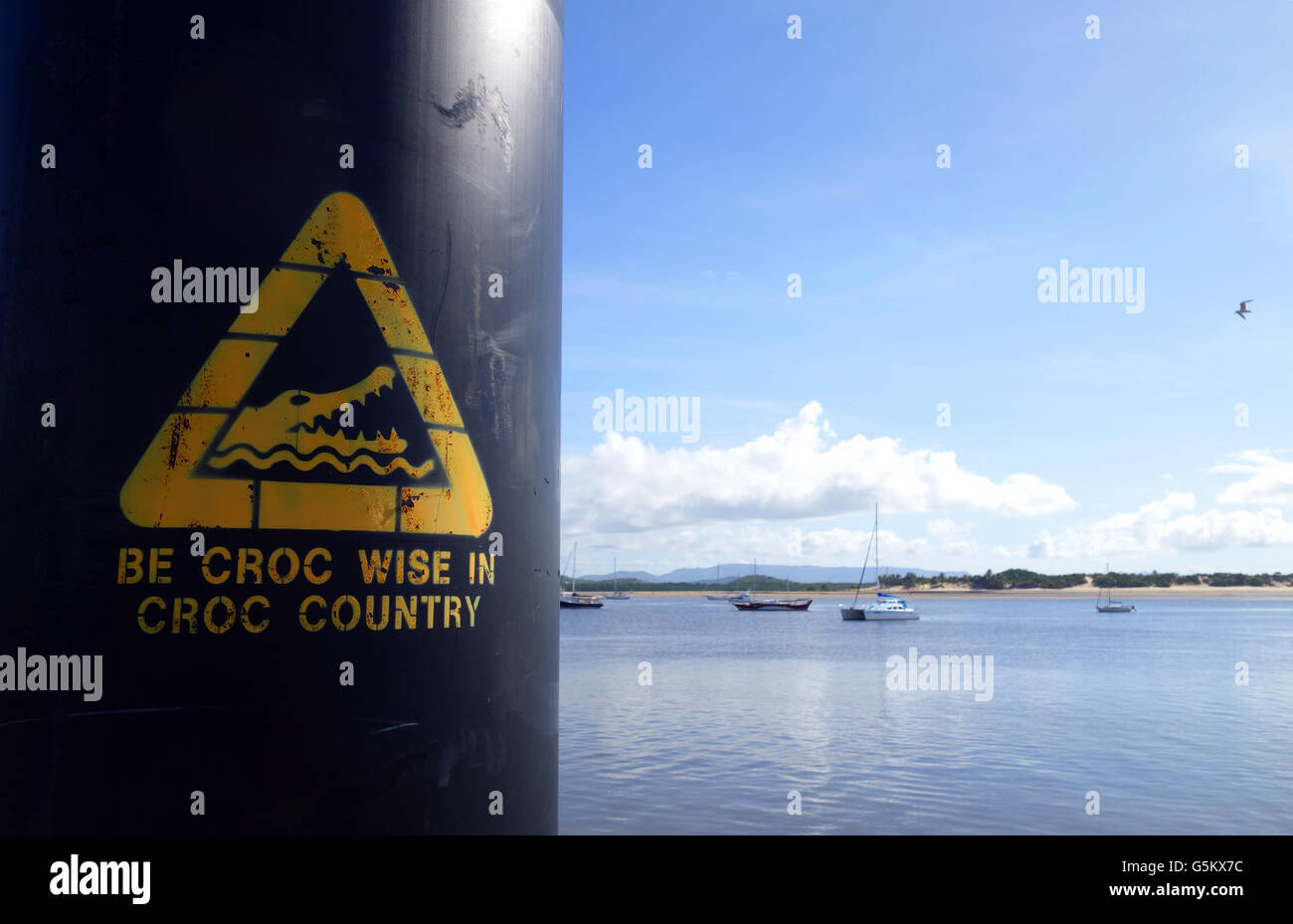 Simbolo giallo di avvertimento circa i coccodrilli a sforzarsi in barca sul fiume rampa, Cooktown, Queensland, Australia. No signor o PR Foto Stock