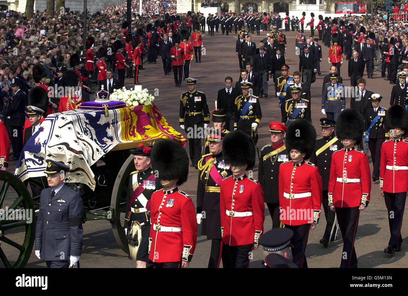 La bara della Regina Elisabetta la Regina Madre passa lungo il Mall mentre i membri maschi della famiglia reale camminano dietro. Foto Stock