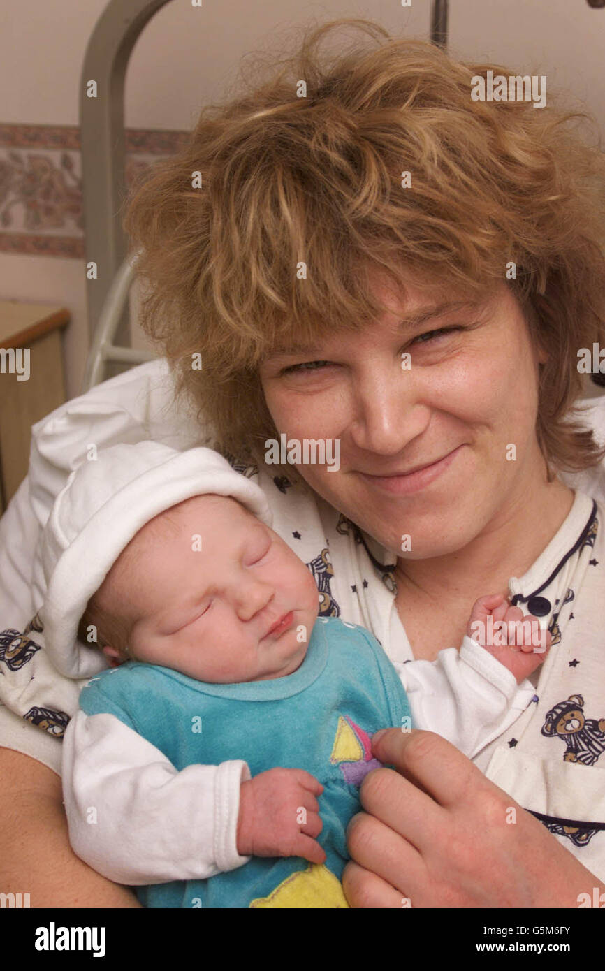 Anne Meier cullerà dolcemente sua figlia Rhea nata alle 12:30 di questa mattina, Capodanno al St Mary's Hospital di Portsmouth, Hampshire. Il personale di sicurezza ha acquistato un orsacchiotto (a sinistra) per celebrare l'occasione del primo bambino dell'ospedale nel 2002. * Rhea non era dovuto per un'altra settimana ed è stato consegnato dalla sezione cesarea. Foto Stock