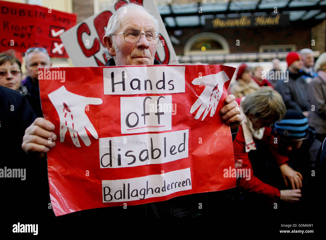 I manifestanti al di fuori della Leinster House, Dublino, si sono schierati contro i tagli proposti dal governo agli aiuti domestici e agli assistenti alle persone con disabilità. Foto Stock
