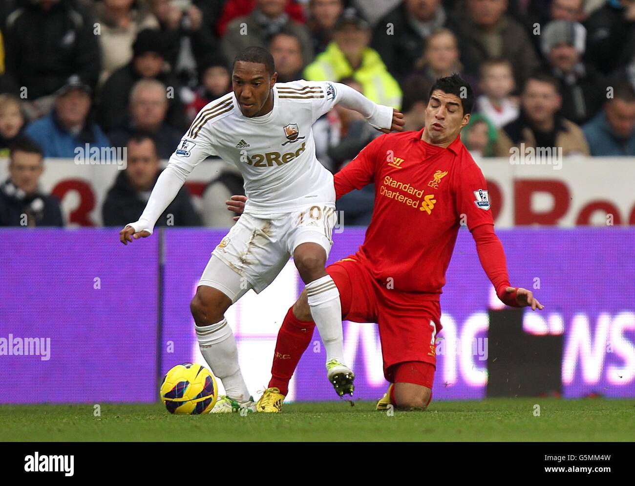 Luis Suarez di Liverpool e Jonathan de Guzman di Swansea City (a sinistra) combattono per la palla Foto Stock