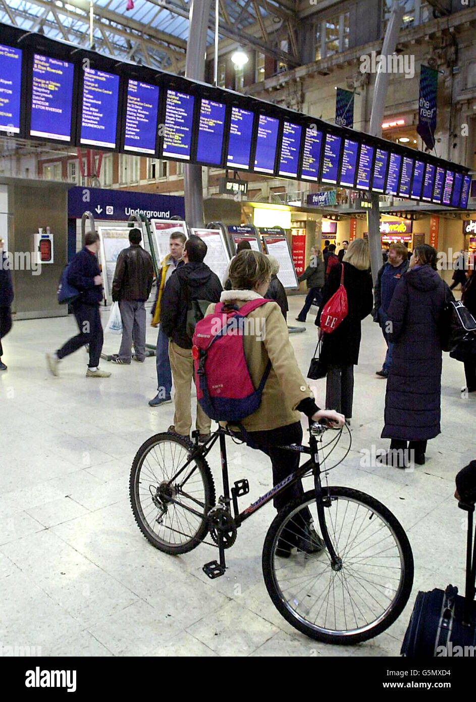 Una donna che viaggia con la sua bicicletta alla ricerca di informazioni sul treno alla stazione di Waterloo di Londra all'inizio dell'ultima disputa ferroviario di 48 ore tra il raccordo ferroviario marittimo e dei trasporti (RMT) e i treni del Sud Ovest (SWT). Foto Stock