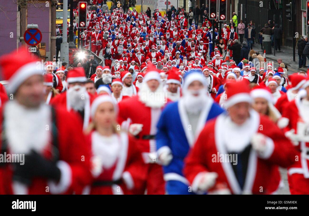 Santa cruscotto. I corridori vestiti con costumi Santa rossi e blu prendono parte al RunLiverpool Santa Dash 2012 a Liverpool. Foto Stock