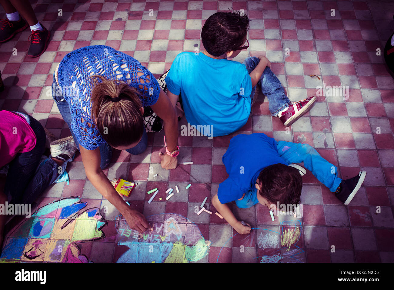 Famiglia di origine ispanica il disegno con un gessetto sul pavimento Foto Stock