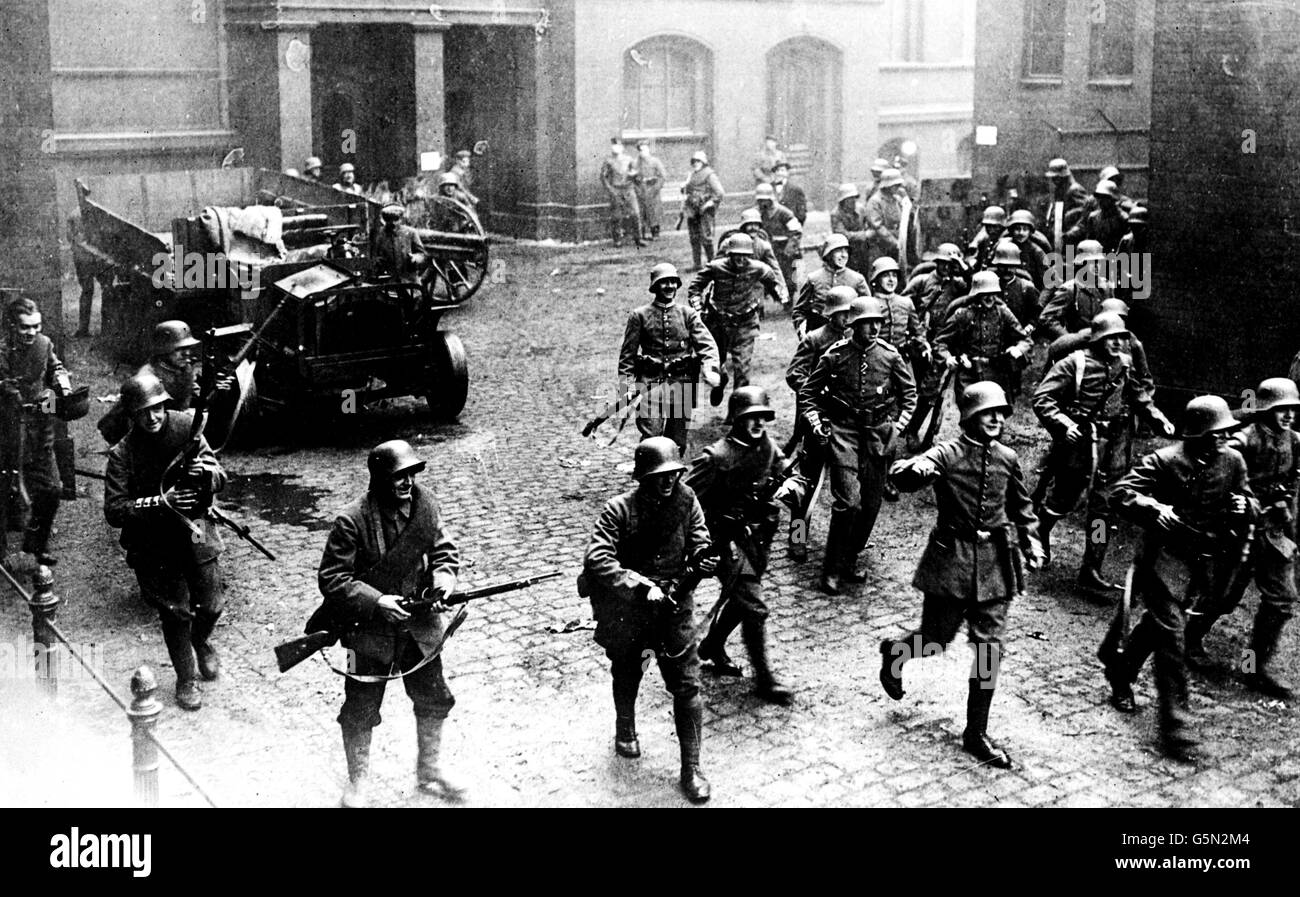 BERLINO 1919: Le truppe del governo tedesco, sostenute dall'artiglieria, avanzano durante gli sporadici combattimenti con gli spartacisti socialisti nella capitale tedesca, Berlino, nel 1919. Le tre strisce di materiale su alcune delle maniche uniformi indicano gli ex guardiani. Foto Stock