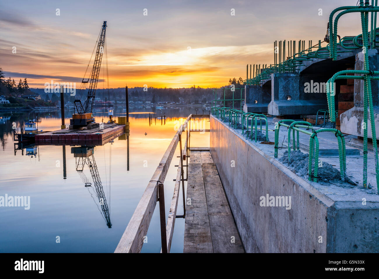 La riflessione di costruzione di ponti e di tramonto in baia ancora Foto Stock