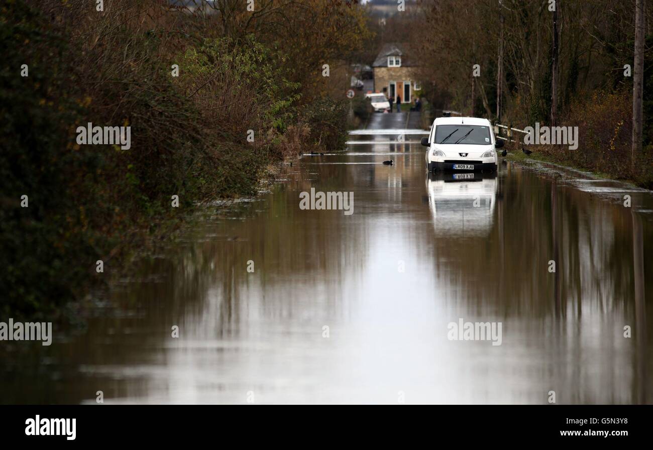 Un furgone bianco è lasciato abbandonato su una corsia di campagna come acque alluvionali dal fiume Nene vicino a una strada in Ringstead, Northamptonshire. Foto Stock