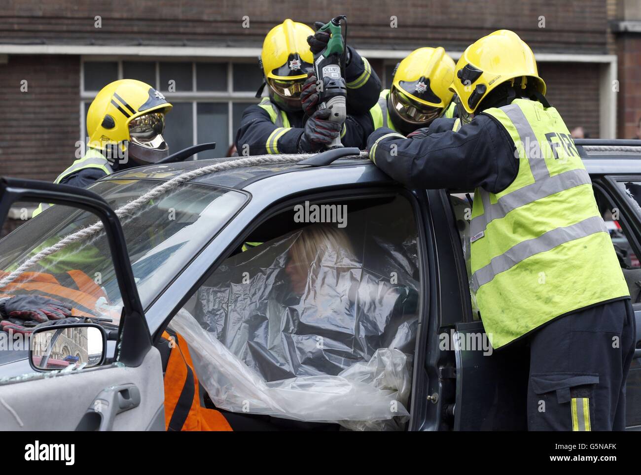 I membri del City of London Road Safety Team, London Fire Brigade, e del City of London Ambulance Service lanciano una campagna di guida anti-drink simulando la rimozione di una vittima da un incidente d'auto di fronte alla stazione ferroviaria di Liverpool Street, Londra. Foto Stock