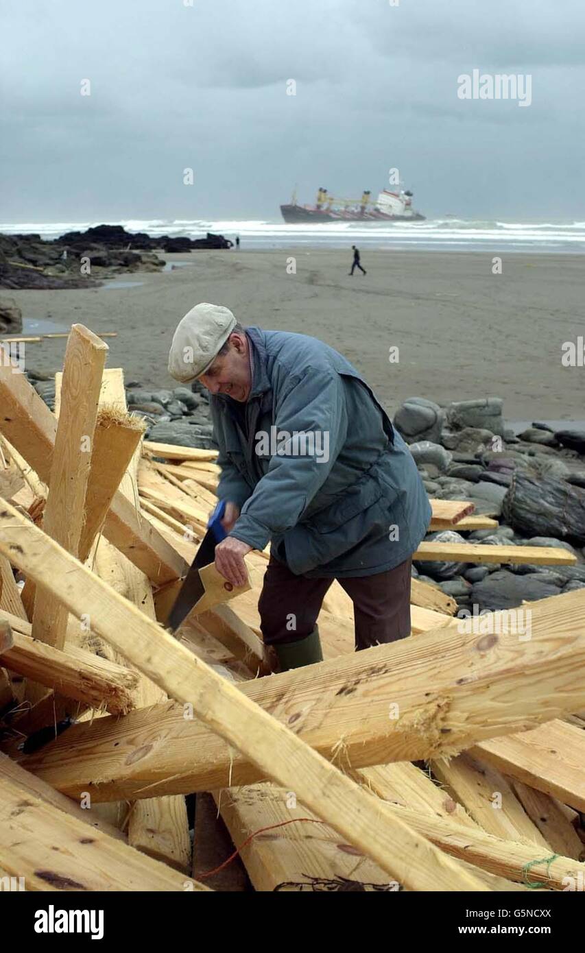 Un uomo tra il legno della petroliera Kodima, bloccato al largo di Whitsand Bay, Cornovaglia, si lava sulla spiaggia. La Kodima, che ha 16 membri dell'equipaggio forte sono stati sollevati in aereo per la sicurezza da un elicottero della Royal Navy ha perso i suoi motori in onde montane a dieci miglia al largo della costa del Devon. * ... ma non si pensa di essere in pericolo imediato di rottura. Un gruppo di salvataggio ha imbarcato la nave per valutare la situazione, ha detto l'Agenzia marittima e di guardia costiera. Foto Stock