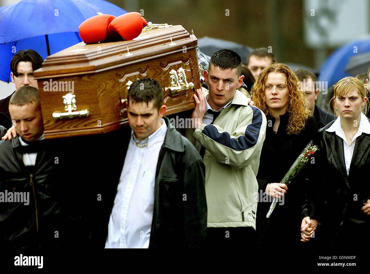 Patrick Burns (davanti a sinistra) porta la bara del fratello Matthew, mentre la famiglia e gli amici camminano dietro, nella loro città natale, Castlewellan, Co Down, Ulster. * ... Matthew Burns, un commerciante locale di droga, è stato ucciso dai pistoleri mentre sedeva con suo fratello in una macchina a Castlewellan. Patrick Burns era in macchina quando i pistoleri attaccarono e fu ferito in mano. Ronnie Flanagan, il Constable capo, ha affermato di non aver escluso il coinvolgimento dell'IRA. Sinn Fein ha negato con veemenza che l'IRA abbia effettuato l'uccisione, descritta dai capi di sicurezza come ben previsto. Foto Stock