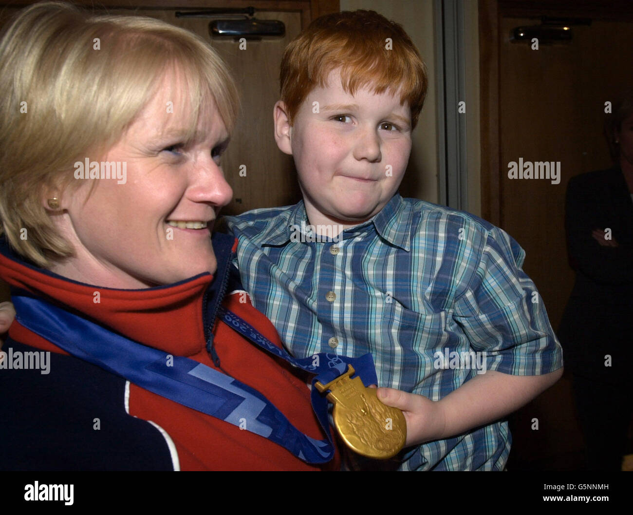 Il figlio di Rhona Martin, Andrew, sei anni, mostra la sua medaglia d'oro alle Olimpiadi dopo che la squadra è tornata all'aeroporto di Glasgow, che ha vinto alle Olimpiadi invernali di Salt Lake City. Foto Stock