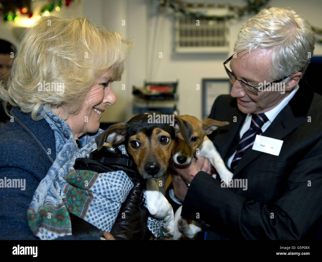 La Duchessa di Cornovaglia si trova accanto a Paul o'Grady mentre tiene i suoi due cani adottì Bluebell e Beth durante la sua visita a Battersea Dogs & Cats Home a Londra, dove ha incontrato personale e volontari. Foto Stock