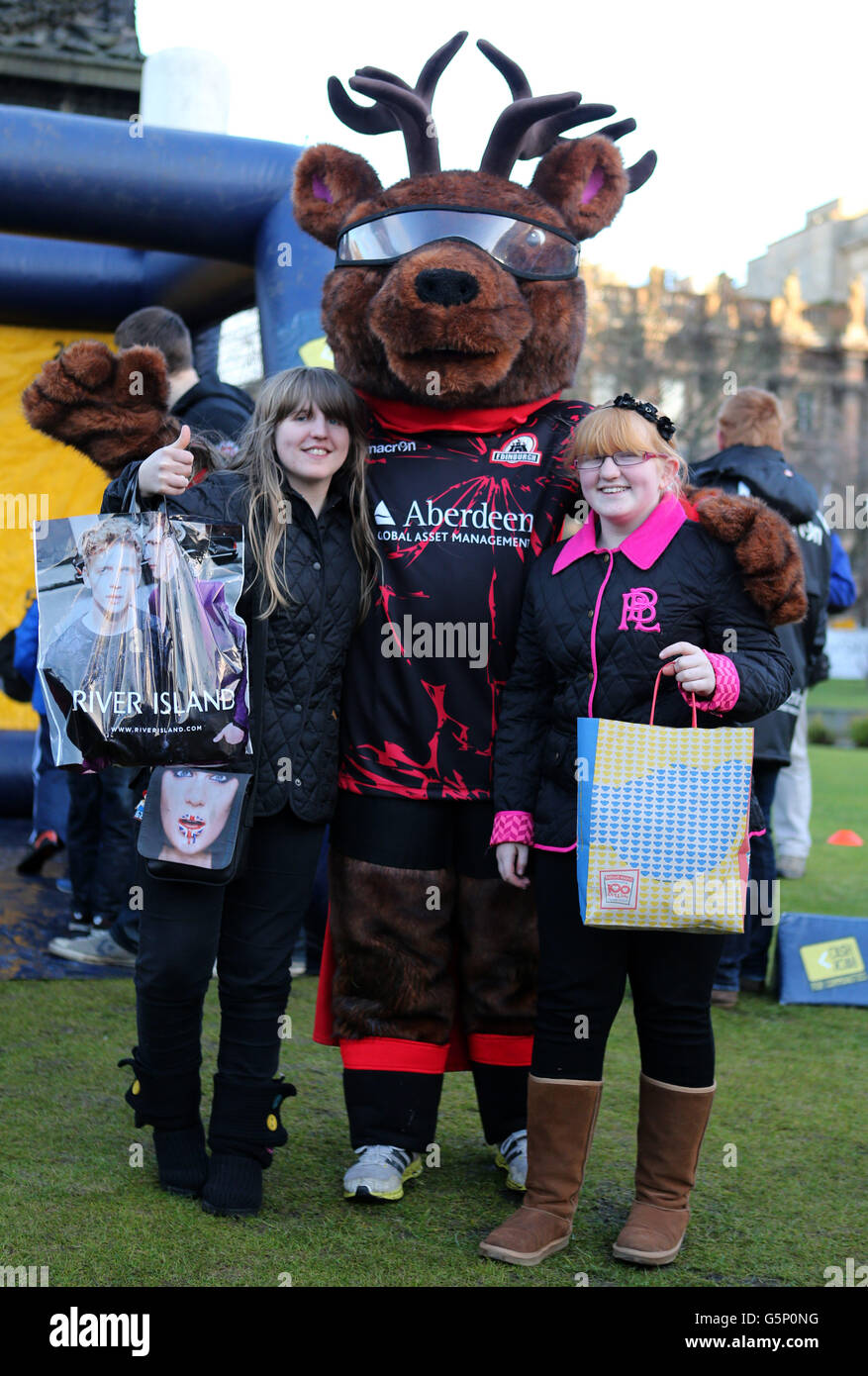 Brooke e Amy Lewis da Manchester con mascotte di Edimburgo, incoraggiando i membri del pubblico a provare la loro mano al rugby durante la giornata di divertimento sportivo del centro città a Edimburgo. Foto Stock