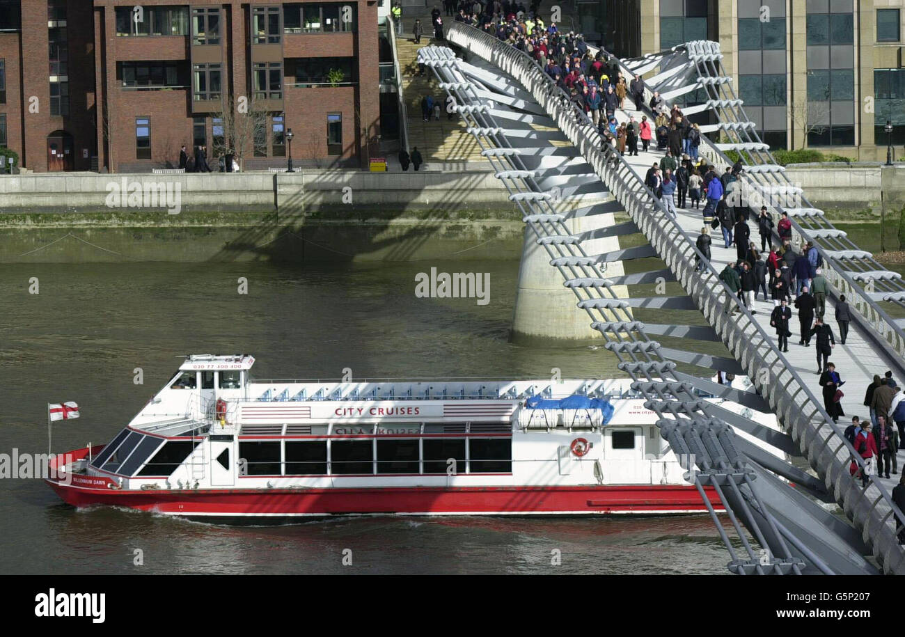 Dopo la riapertura a Londra, dopo una modifica di 5 milioni di euro, gli escursionisti controllano la presenza di eventuali vortici sul Millennium Bridge sul Tamigi. Il ponte da 18.2 milioni di persone ha subito un'oscillazione sotto il peso di migliaia di pedoni quando è stato inaugurato nel giugno 2000. * dopo soli tre giorni gli operatori del ponte dovettero chiudere la struttura lunga 320 metri, che va dalla cattedrale di St Paul a nord del Tamigi a Londra fino a Tate Modern sulla riva sud. Foto Stock