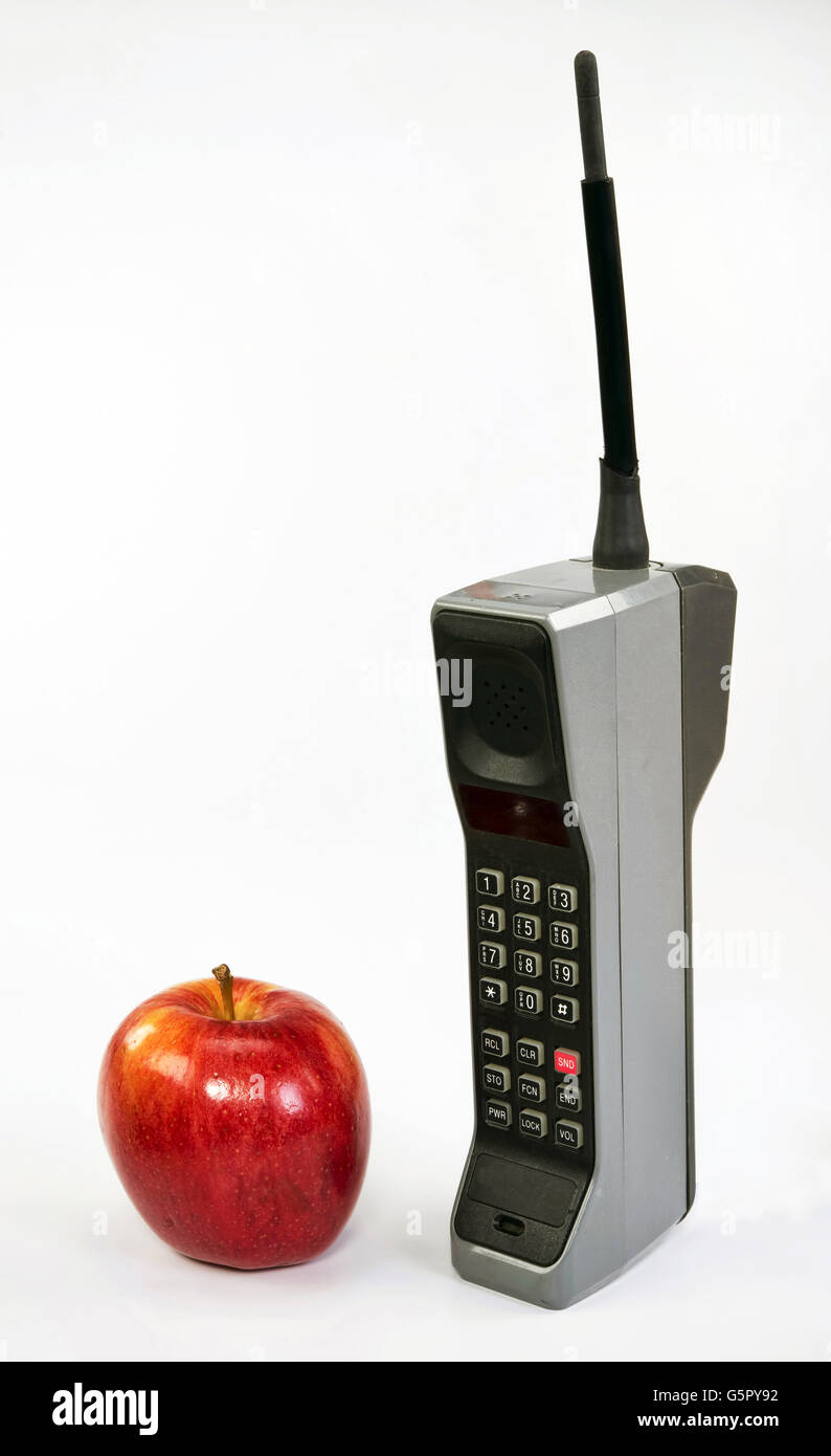 Red apple e grande in mattoni vecchio stile telefono cellulare. Foto Stock