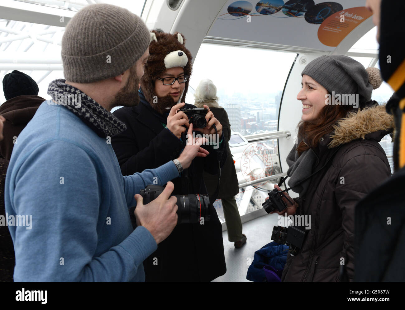 1000 persone hanno sfidato le condizioni meteorologiche avverse al EDF Energy London Eye questa mattina, accodandosi nella neve per la riapertura dell'"Lift London" e per una rotazione libera. Foto Stock