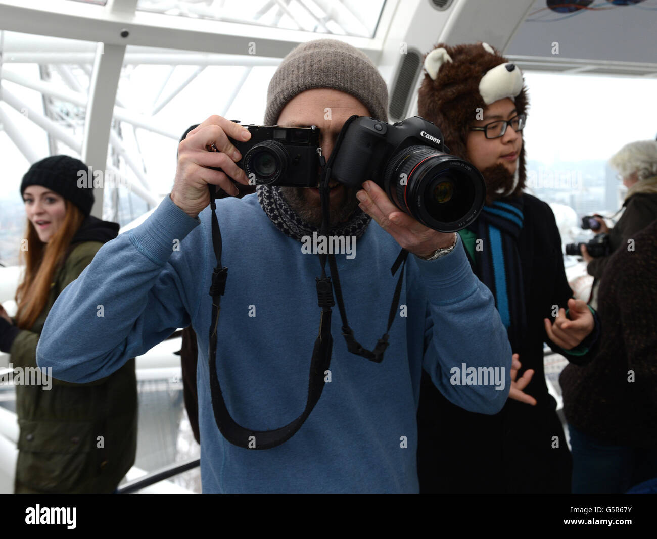1000 persone hanno sfidato le condizioni meteorologiche avverse al EDF Energy London Eye questa mattina, accodandosi nella neve per la riapertura dell'"Lift London" e per una rotazione libera. Foto Stock