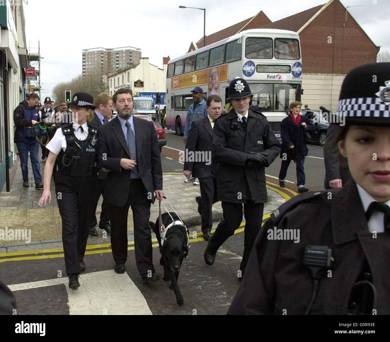 Il segretario all'interno David Blunkett (al centro) è aiutato dall'ispettore di settore Jeanette Harris durante la sua visita ai negozianti di Stapleton Road, Bristol, * il giorno stabilito nuove linee guida stop-and-search che sono progettate per contribuire a ripristinare la fiducia nel modo in cui la polizia si occupa delle minoranze etniche. Le nuove misure faranno sì che tutti i poliziotti si fermeranno con un certificato che spiegheranno perché sono stati fermati. Foto Stock
