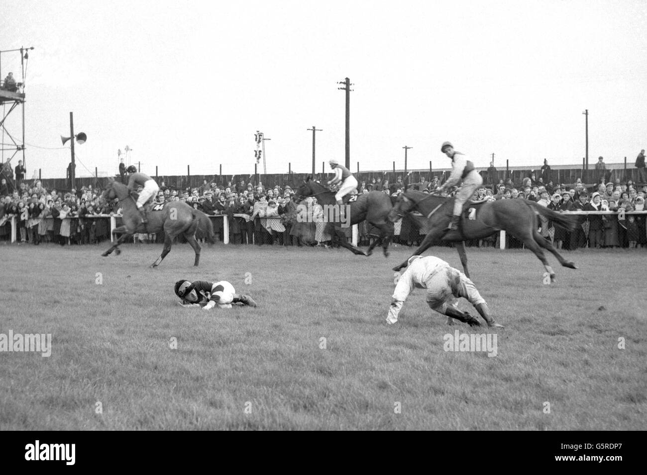 Il T. Carberry di Fallen Jockey, che stava cavalcando 'impaccato' e G. W. Robinson, che stava cavalcando 'Popham giù', si raccolgono dopo essere caduti al Brook di Becher. Passerai davanti al cavallo giapponese "Jujino-o", J. King up. Foto Stock