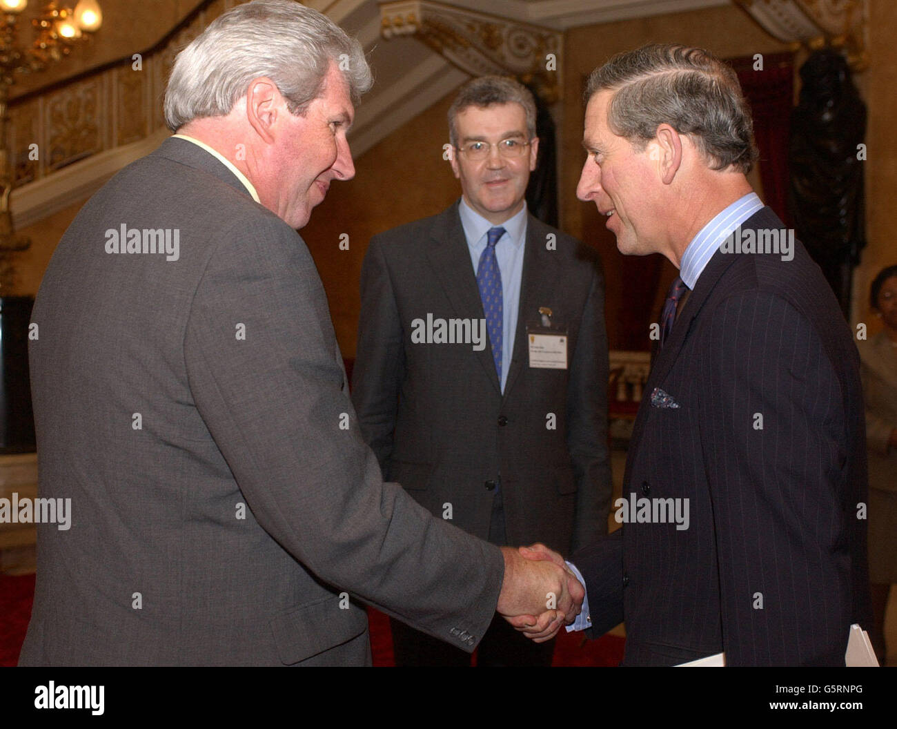 Il Principe di Galles scrolla le mani con il MP Elliot Morley, con John Dew (centro), capo del Dipartimento America Latina e Caraibi presso il Foreign Office, prima che il Principe Charles si occupi di una conferenza sull'agricoltura biologica caraibica nel centro di Londra. * il principe esortava i supermercati a seguire il suo esempio, lanciando la sua marca di cioccolatini a base di cacao biologico coltivato in Guyana, dove il suo coinvolgimento sta aiutando a rivitalizzare una comunità impoverita. Charles ha detto che i suoi tini organici di cioccolato scuro, prodotti dalla sua azienda di alimenti Ducati Originals, stavano permettendo agli Amerindi nella Guyanian Foto Stock