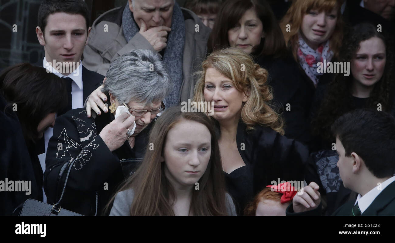 Myra Fallon (a sinistra), asciuga via una lacrima mentre è confortata durante i funerali di suo marito, ex assistente manager celtico Sean Fallon, alla chiesa del Cristo Re a Glasgow, Scozia. Foto Stock