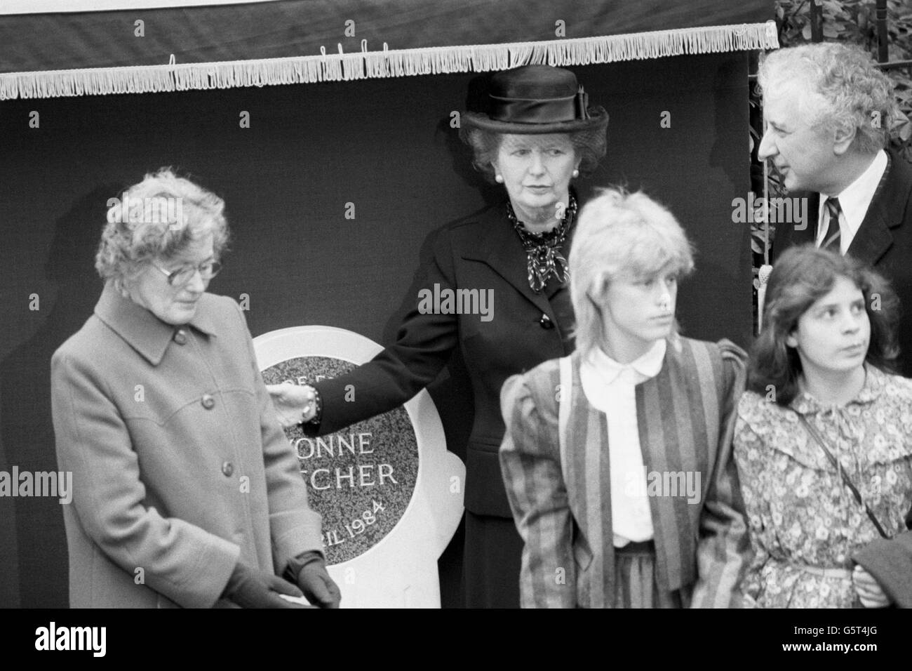 Il primo ministro Margaret Thatcher e il regista Michael Winner stanno dietro la famiglia del poliziotto assassinato Yvonne Fletcher. Sua madre Queenie e le sorelle Heather (sinistra), Debbie (destra) e Sarah, hanno partecipato alla presentazione di un memoriale all'ufficiale in St James's Square, Londra. Foto Stock