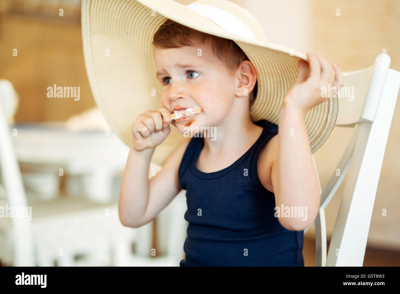 Bel bambino earing gelato in salotto Foto Stock
