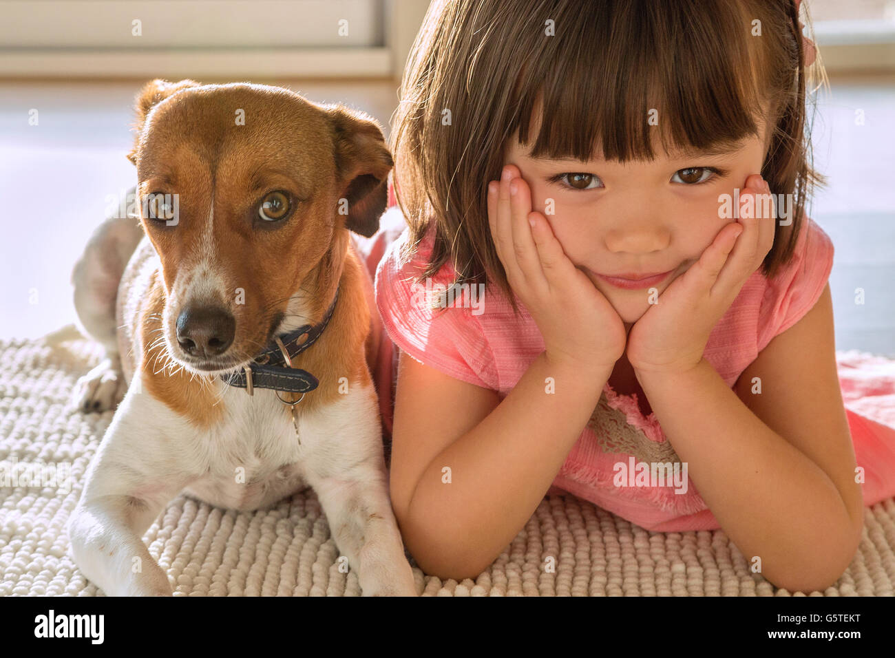Un bambino ragazza seduta con il suo cucciolo pet Foto Stock