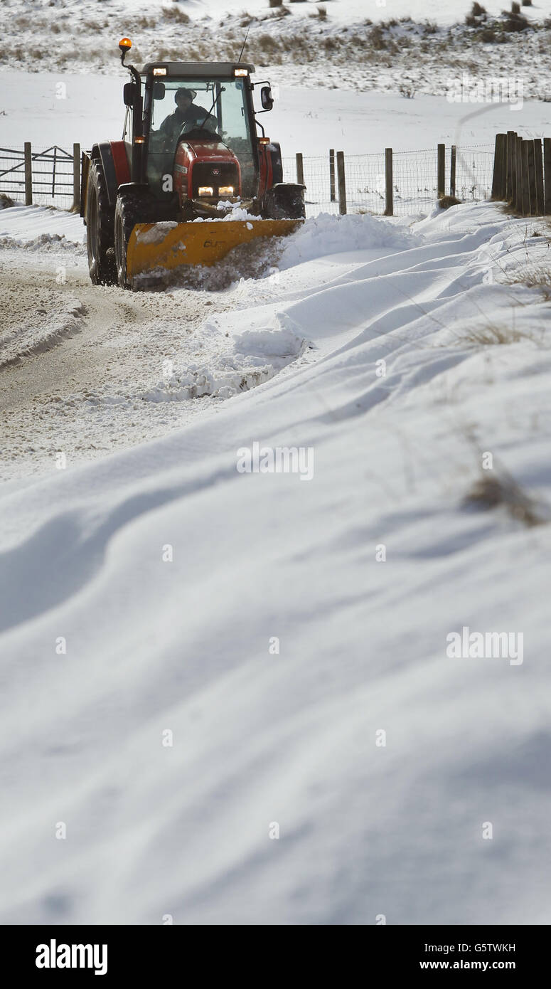 Un aratro da neve lavora per eliminare la neve da una strada ad Abington in Scozia. Foto Stock