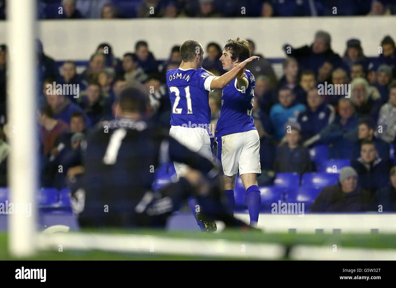 Il portiere di West Bromwich Albion ben Foster (in primo piano) si siede espulso come Everton's Leighton Baines (a destra) celebra il primo obiettivo di Everton Il gioco con il compagno di squadra Leon Osman Foto Stock