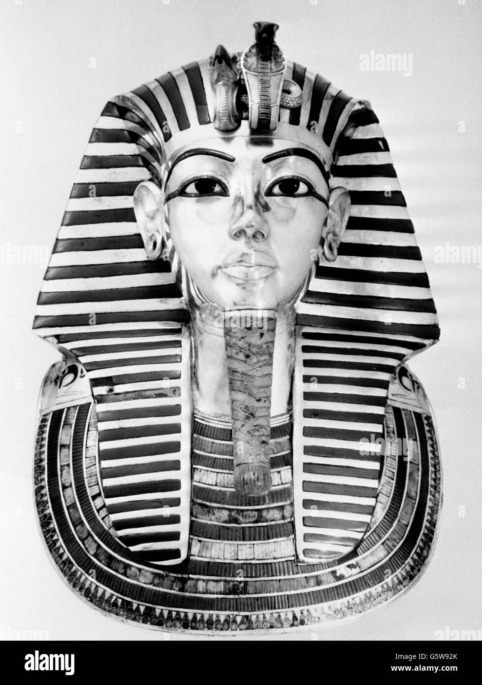 Una maschera funeraria, che è tra i tesori di Tutankhamun ora in mostra al British Museum di Londra. È oro solido, intarsiato con pietre semi-preziose e vetro, ed è alto 21 pollici e largo 15-e-un-mezzo pollici alle spalle. Foto Stock