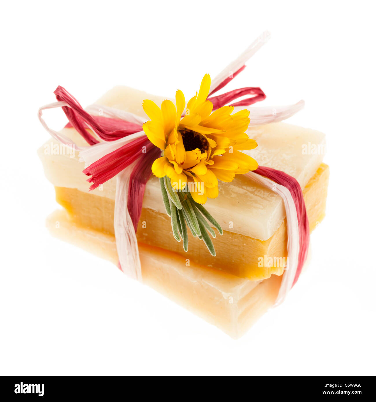 Diversi fatti a mano a base di erbe sapone artigianale pezzi legati con fiori freschi isolati su sfondo bianco Foto Stock