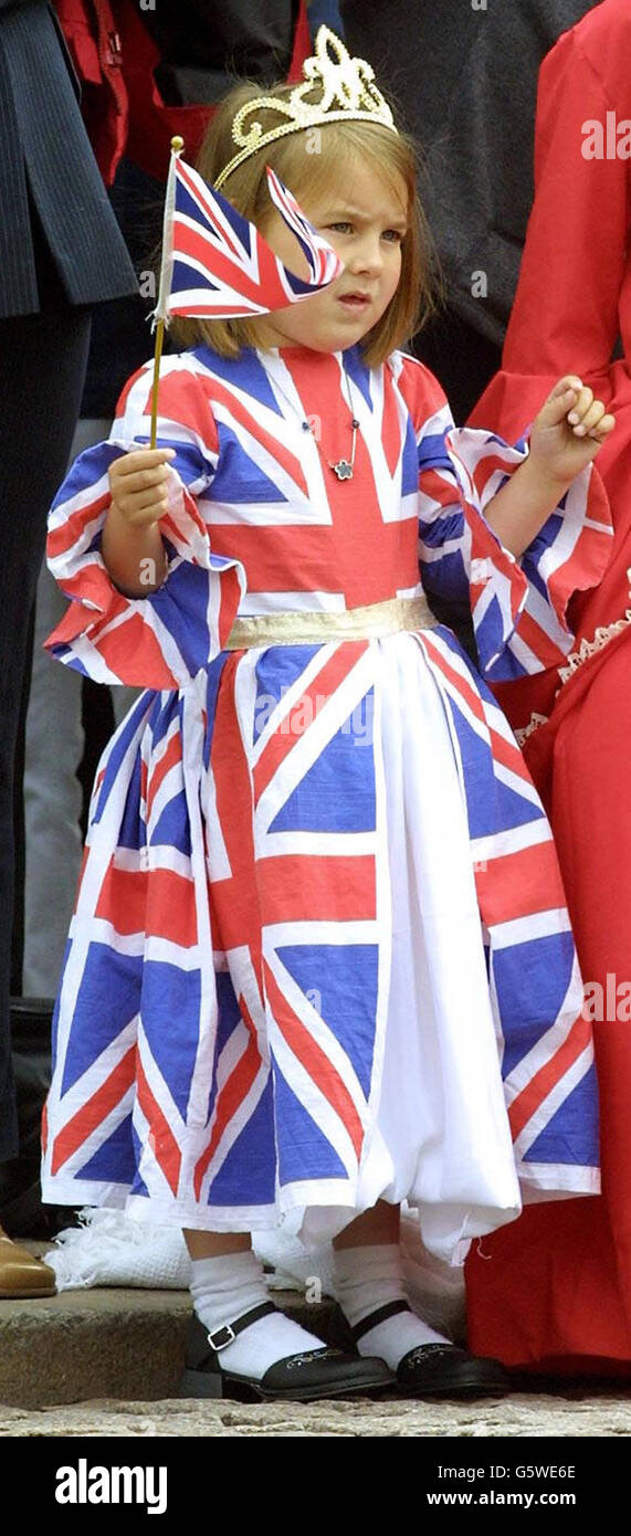 Una ragazza indossa un abito Union Flag mentre guarda la processione fuori Buckingham Palace durante le celebrazioni del Giubileo d'oro a Londra. La regina Elisabetta II celebra il suo Giubileo d'oro dopo 50 anni sul trono. Foto Stock