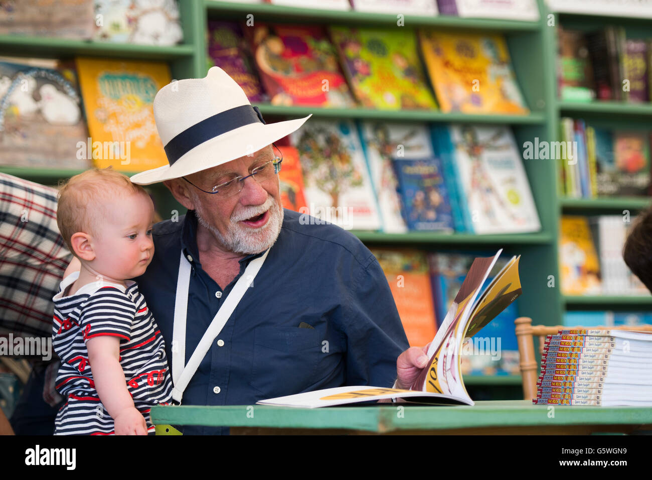 Un anziano uomo la lettura di un libro di un giovane bambino a Hay Festival della letteratura e delle arti, Hay on Wye, Powys, Wales UK, domenica 05 giugno 2016 Foto Stock