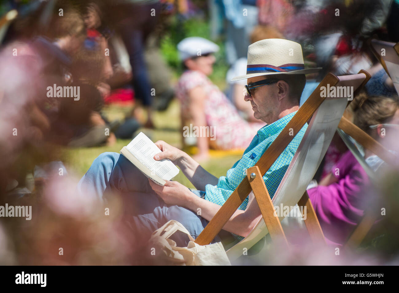 Le persone la lettura di libri nel caldo sole estivo presso la Hay Festival della letteratura e delle arti, Hay on Wye, Powys, Wales UK, Giugno 03 2016 Foto Stock