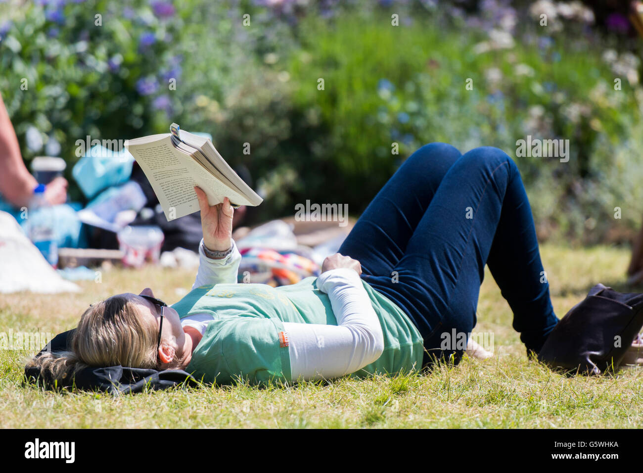Le persone la lettura di libri nel caldo sole estivo presso la Hay Festival della letteratura e delle arti, Hay on Wye, Powys, Wales UK, Giugno 03 2016 Foto Stock