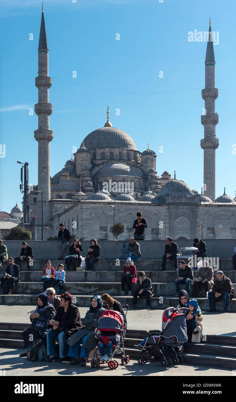 Le persone in un momento di relax a Eminonou lungomare vicino al Ponte di Galata, con la moschea Yeni in background, Istanbul, Turchia. Foto Stock