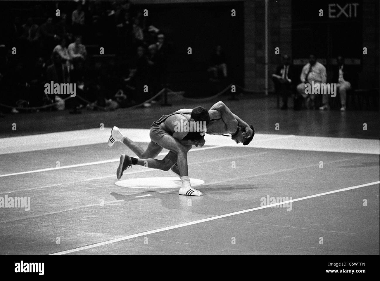 Il wrestler indiano Ved Parkash (stivali bianchi) di 14 anni che sta per lanciare M Sadik dal Pakistan nel primo round di British Commonwealth Games Light flyweight wrestling. Foto Stock