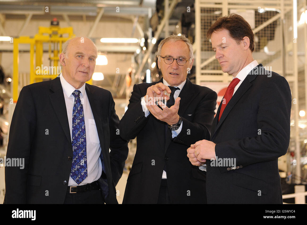 Il vice primo ministro Nick Clegg e il ministro degli Affari vince Cable (a sinistra) parlano con l'amministratore delegato di Aston Martin Dr Ulrich Bez (al centro) durante un tour della sede centrale di Aston Martin a Gaydon, nel Warwickshire. Foto Stock