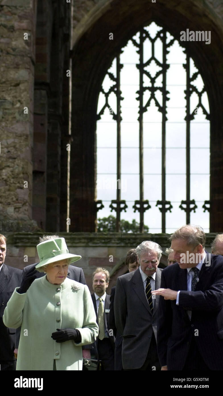 La Regina parla con Graham Munroe della Historic Scotland Society mentre visita l'abbazia di Melrose, nei confini scozzesi. La Regina visitò dove fu sepolto il cuore del re scozzese medievale Robert Bruce. Foto Stock