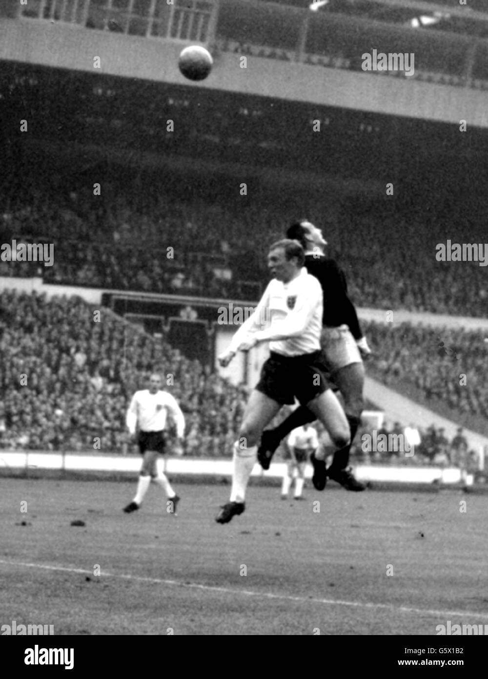 Il centro scozzese in avanti St.John (camicia scura), batte la metà destra dell'Inghilterra Bobby Moore alla testata, durante l'International a Wembley Stadium. Foto Stock