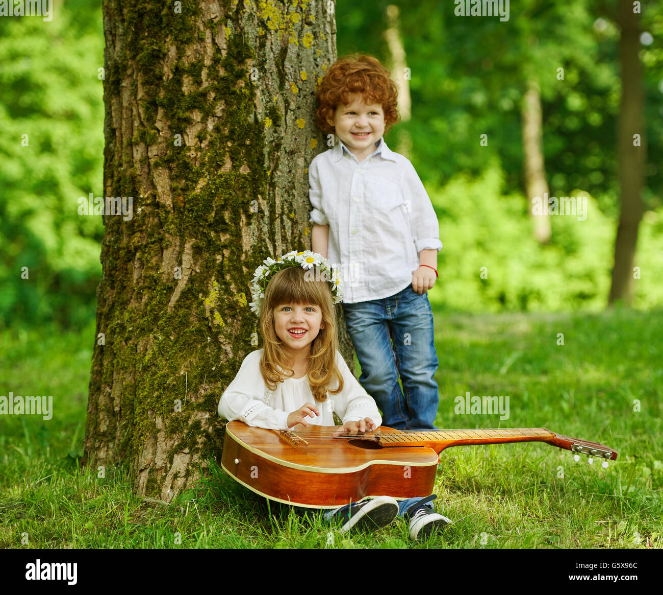 Carino bambini suonando la chitarra Foto Stock