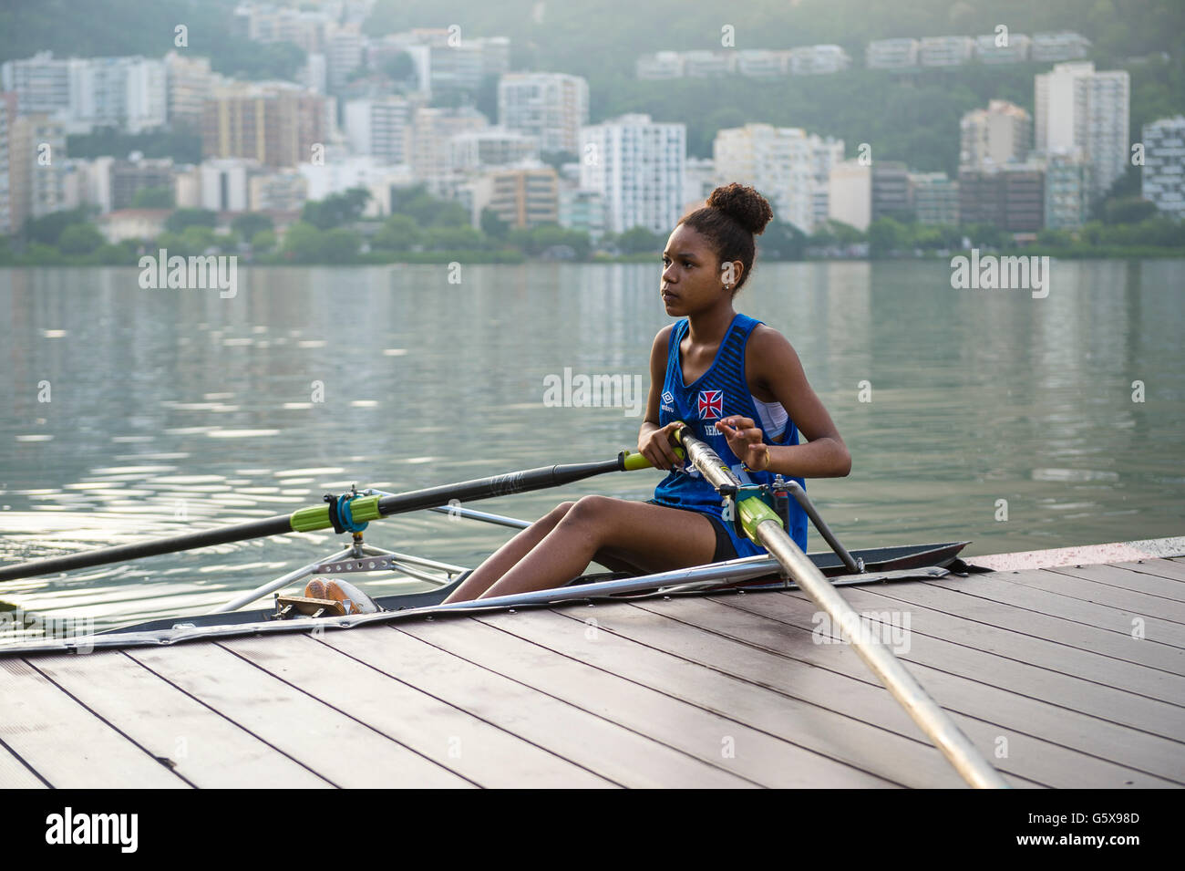 RIO DE JANEIRO - Aprile 1, 2016: un giovane brasiliano carioca rower lancia la sua barca al fianco di un molo a Lagoa Rodrigo de Freitas. Foto Stock