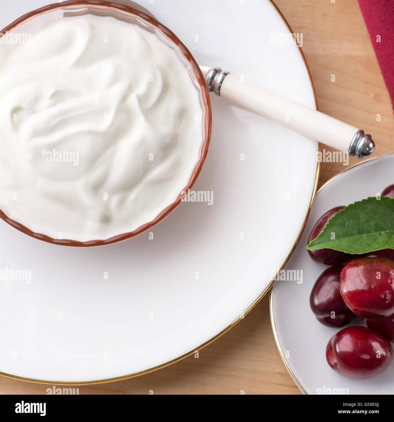 Tettuccio di vista sulla piazza di spessore naturale cremoso yogurt greco con frutta estiva sana colazione pasto impostato sul tavolo. La dieta Foto Stock