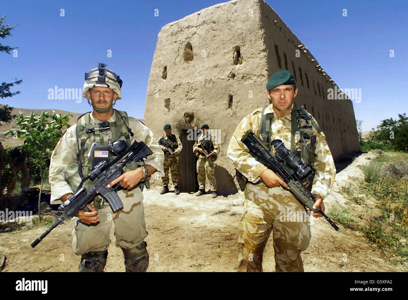 Un membro delle forze speciali statunitensi si erge con una Royal Marine  britannica fuori dal granaio di mattoni di fango nel villaggio di Atalay, a  50 miglia a nord-ovest di Kandahar, nel