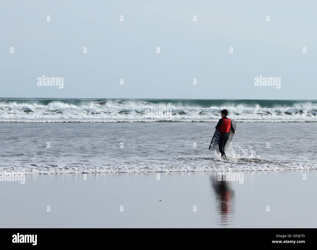 Camminare verso grandi onde da surf Foto Stock