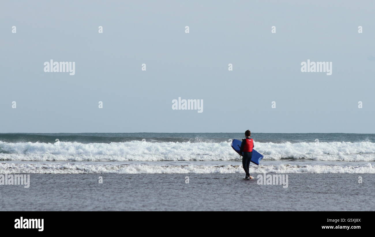 Ragazzo attorno al corpo surf in grandi onde Foto Stock