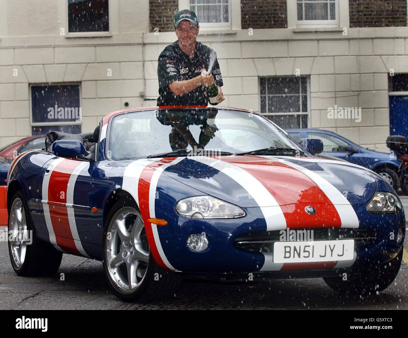 Eddie Irvine, pilota di Formula uno, lancia sia l'apertura della 'F1', una nuova mostra fotografica presso la fiera Camden gallery, sia la livrea bandiera di Austin Powers Jaguar in Union. Foto Stock