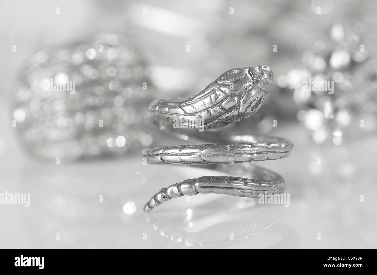 Anello in argento a forma di serpente e altri gioielli. Foto Stock